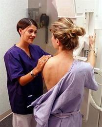Technician helping woman during mammogram